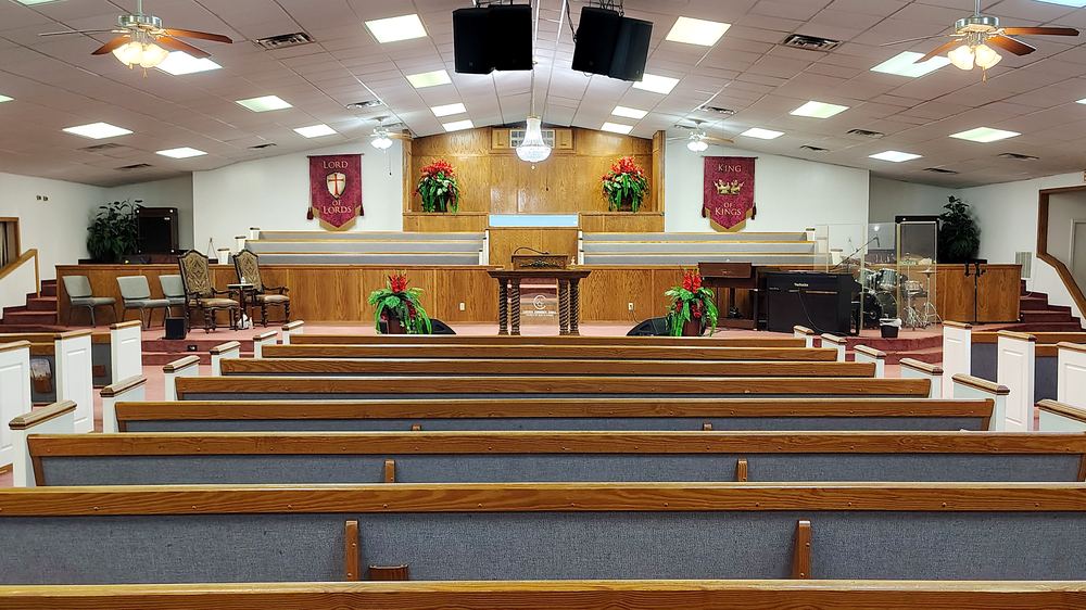 Pews and pulpit of Lakeview Community Temple, with the Lord of Lords and King of Kings banners on either side